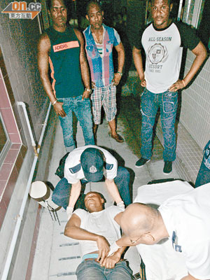 報稱受傷非洲漢躺臥地上，救護員即場替其檢驗。（楊日權攝）