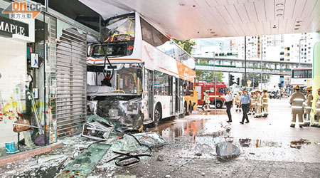 巴士撞入商場時裝店，玻璃碎片及雜物散布地上。（曾紹良攝）