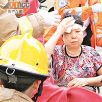 被撞倒的婦人在場接受救護員敷治。