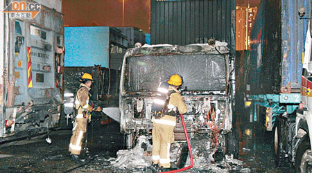 起火貨櫃車嚴重焚毀，消防員在現場調查。（葉嘉文攝）