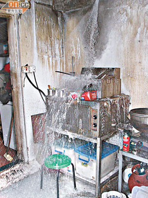 爐邊喉管被燒毀噴水，令廚房水浸。（吳欽旺攝）