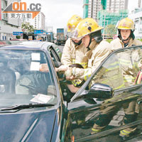 消防員協助私家車司機爬出車外。（梁卓明攝）