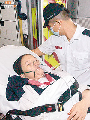 被壽司刀插傷的女工由救護員送院治理。（冼耀華攝）