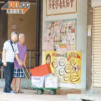 自稱屬澤安邨居民協會的男子（左）與「食物回收大使」（右），昨早用手推車把兩大箱麵包送至辦事處。