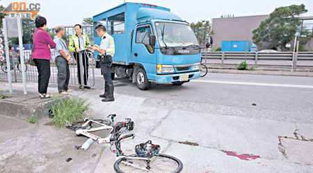 貨車司機（左二）協助警方調查，現場可見遭撞毀的單車及大攤血漬。（張曉楠攝）