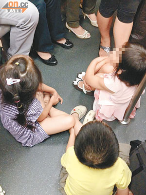 三名小童於港鐵車廂內席地而坐，影響其他乘客。
