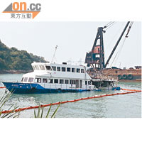 沉沒的「南丫IV」被拖到牙骹灣停泊，可見其船尾嚴重毀爛，四周圍有隔油污帶。（黃子源攝）