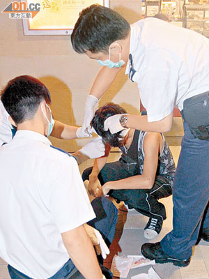 被兇徒用啤酒樽扑傷頭的少年由救護員急救。