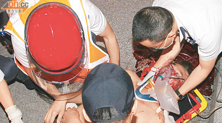 男子被撞飛彈墮地重傷，救護員在場搶救。（賴南秋攝）  