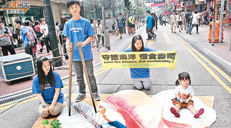 綠色和平昨於銅鑼灣行人專用區擺放魚類刺身立體畫呼籲市民避免進食瀕危魚類。（陳章存攝）