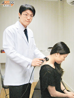 王俊華（左）示範為頸椎移位的病人，以儀器協助放鬆肌肉。