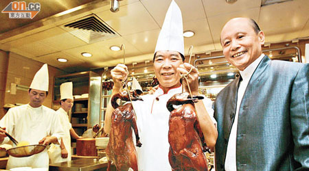 甘健成（右）與鏞記馳名的燒鵝。