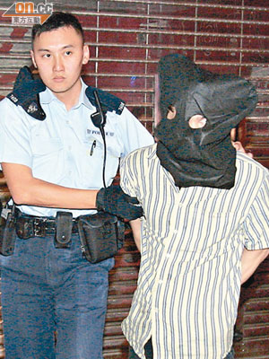 藏身快餐店圖偷竊的男子被警員拘捕帶署。（王偉安攝）