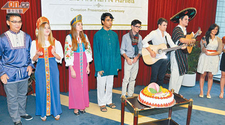 穿上民族服裝嘅科大學生向夏利萊高唱生日歌。