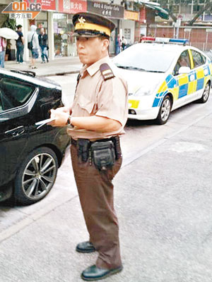 交通督導員到場向違泊警車發告票。（讀者提供）
