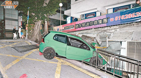 跑車掃毀鐵欄後前半身跌出路邊。（楊偉嶽攝）