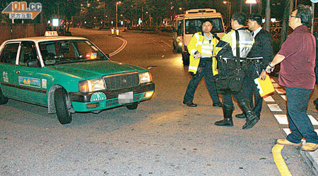 的士被指撞及輪椅漢，警員到場向司機（右）調查。