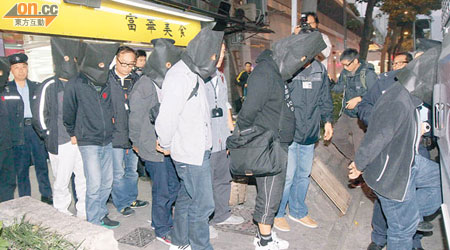 七名涉受聘燒錄色情光碟的內地男子，被警方拘捕帶走。（梁志雄攝）