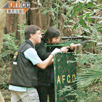 女獸醫（右）向野豬發射麻醉槍。