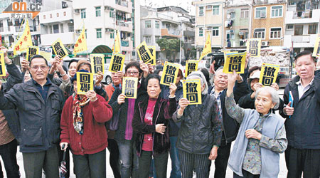 新界原居民高舉標語，要求港府撤回新界村屋僭建物申報計劃。（蔡綺琳攝）