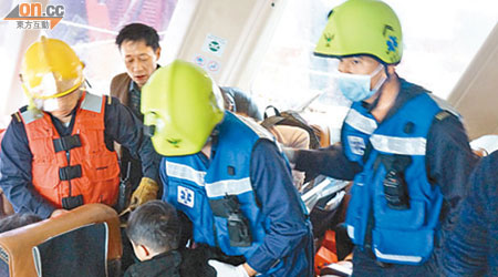 救護人員到場將受傷男童抱出船艙。（讀者提供）