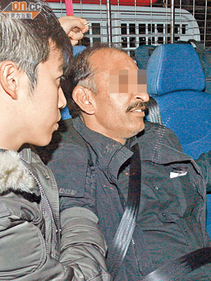 涉案南亞裔保安員（右）由警員帶署。（楊偉嶽攝）