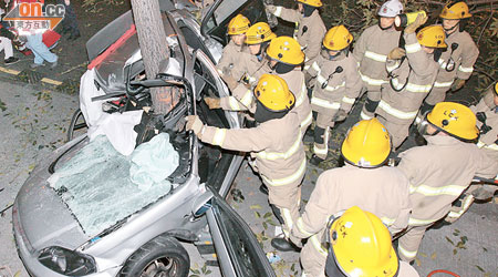 私家車車身如「V」字形摺曲，消防員正拯救被困司機。（梁國雄攝）