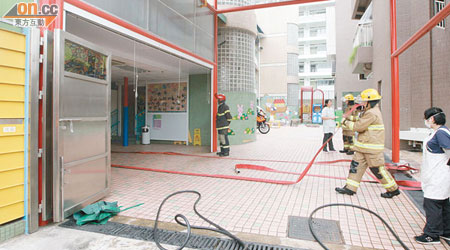 消防員進入發生火警的幼稚園調查。（林少兒攝）
