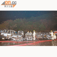 消防員檢查被焚毀的汽車。