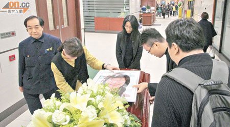 遺照及百合花置放在曾詩樂醫生靈柩上。（蕭毅攝）