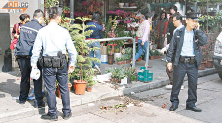 小狗墮樓時壓毀花店一些盆栽，警員到場調查。（戴展邦攝）