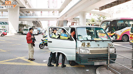 客貨車司機懷疑病發昏迷失控撞欄，警員在現場調查。 （林少兒攝）