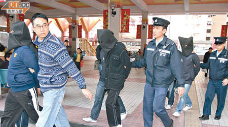 在樂華北邨被捕的三名男子由警員押走。（梁志雄攝）