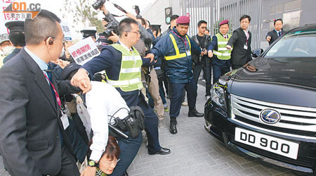 一名女警將躺在地上的區議員方國珊移走，讓開一條路給車輛駛離。（陸智豪攝）