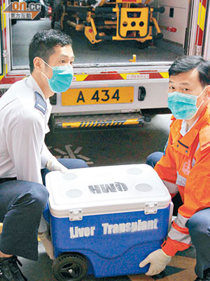 救護員將載有器官的冰箱搬上救護車，運送到其他醫院進行移植手術。（陳桂建攝）