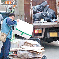 身穿食環署制服的職員將貨車停泊菜檔門外後，即以極速收集菜檔棄置垃圾。