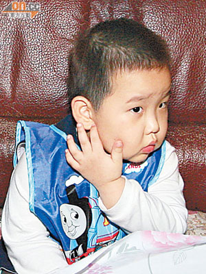 男童一臉驚慌，指示被夾致紅腫的耳朵。（馬竟峯攝）