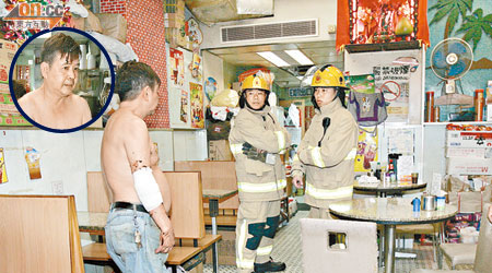 東主（左）向消防員講述救火經過。