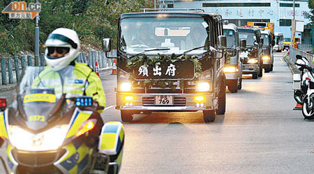 運送死難者遺體的車隊由警方電單車開路，前往葵涌公眾殮房。（陳德賢攝）