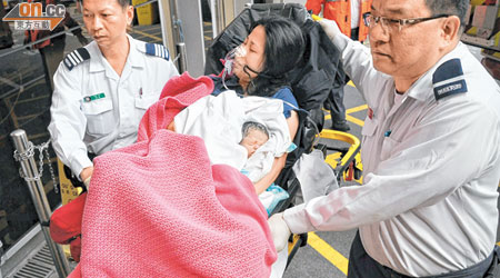 在的士上分娩的婦人與新生嬰孩由救護員送院。(郭錦良攝)