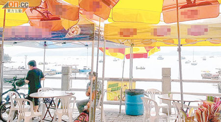 大美督路有店舖疑將枱椅及太陽傘放於官地上，被指造成阻塞。(讀者提供)