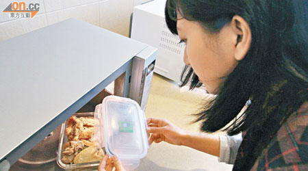 市民將盛載食物的保鮮盒放入微波爐時，應多加注意容器的耐熱程度。（梁耀榮攝）