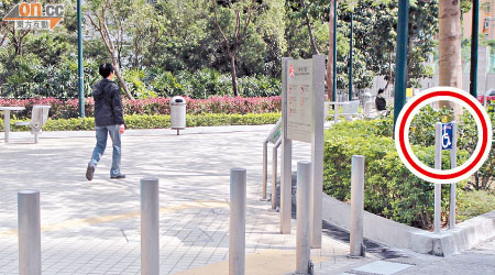 公園出入口豎立多支鐵柱，與展示的傷殘人士通道標誌（紅圈示）格格不入。