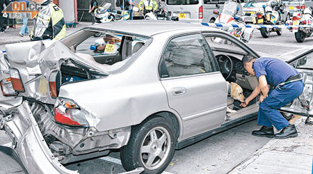 肇事私家車車尾損毀，警員到場搜車。