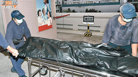 仵工將墮樓外籍婦人的屍體由醫院舁送殮房。（林耀康攝）