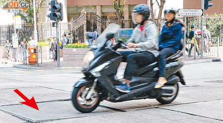 皇后大道西與皇后街交界路面損毀（箭嘴示），鬆脫部分猶如「搖搖板」，每有車輛駛過均會發出聲響。