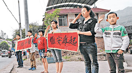 在去四川地震災區途中，一些學生手舉「雅安雄起、一路平安」橫幅。（中新社圖片）