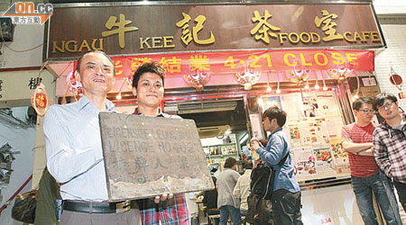 牛記茶室老闆麥炳權（左）及兒子麥浩源，展示所擁有的木製古董食肆牌照。（陳章存攝）