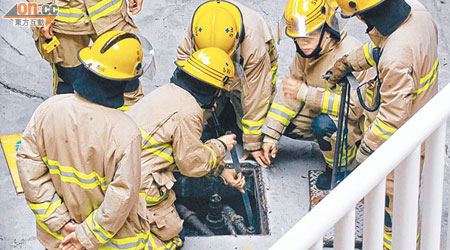 消防員用工具在地底油缸搜尋手機。（馬竟峯攝）