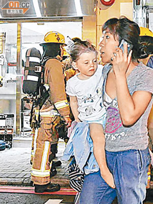 抱着幼主的女傭，慌張逃至街上。 (李國健攝)